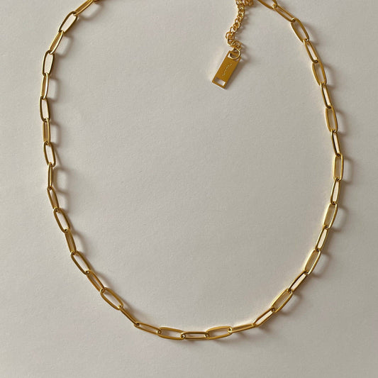 Gold chain necklace on a light gray background